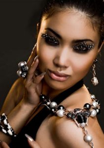 Woman posing with custom jewelry on her neck and arms.